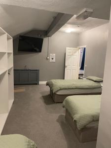 a bedroom with two beds and a tv on the wall at Top of the Town in Eas Géitine