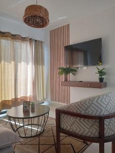 Una sala de estar con una mesa y un televisor. en Departamento Relax, en Mazatlán