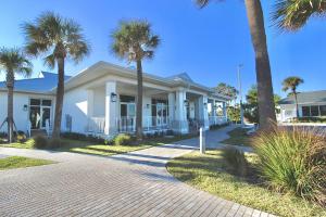 a white house with palm trees in front of it at Seaside Escape in Fort Pierce