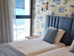 a bedroom with a bed with a view of the ocean at Casa Linda Baía in Porto da Cruz