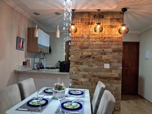 a dining room with a table and a brick wall at Casa do sossego in Cabo Frio