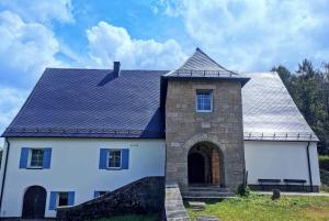 a white house with a gray roof at Wellness Hostel Polskie Wrota in Lewin Kłodzki