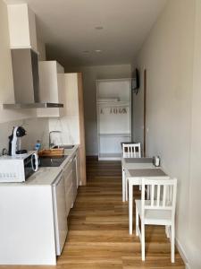 a kitchen with white cabinets and a table and chairs at Apartamentos Buenos Aires,en el centro de Ribadeo con vistas a la ría in Ribadeo