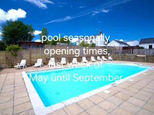 a swimming pool in a yard with chairs around it at Holiday Home - St Austell in St Austell