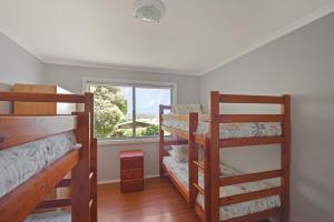 two bunk beds in a room with a window at 158 Wallaga Lake in Bermagui