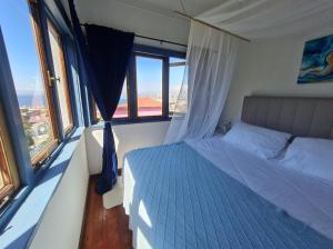 a bedroom with a bed in a room with windows at Hotel boutique Paihuen in Valparaíso