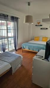a bedroom with two beds and a desk with a computer at DOWNTOWN-GuestHouse in Olhão