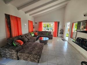 Una sala de estar con sofás y un televisor. en Villa Jireh, en Willemstad