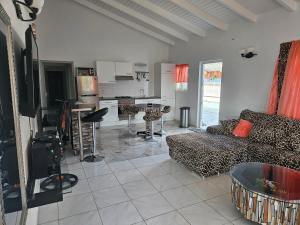 Una sala de estar con un sofá y una cocina. en Villa Jireh, en Willemstad