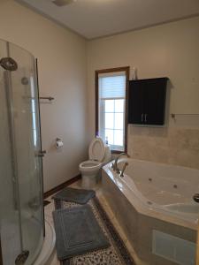 une salle de bain avec une baignoire, des toilettes et une douche dans l'établissement Cottage apartments at Lake Huron, à Midland 29 autres photos