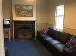 a living room with a couch and a fireplace at Pemberton in Beechworth