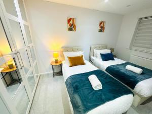 two twin beds in a room with a mirror at Gillingham Home with garage in Rainham