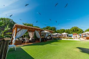 eine Outdoor-Veranstaltung mit Stühlen und Sonnenschirmen auf einem Rasen in der Unterkunft Pao Pao Hotel & Beach Club in Isla Grande