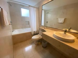 a bathroom with a sink and a toilet and a mirror at Suites Giorgio in Mexico City +44 photos