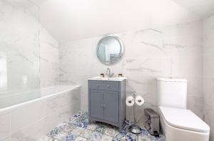 a white bathroom with a sink and a toilet at Mount Auldyn House - The Cottage in Ramsey