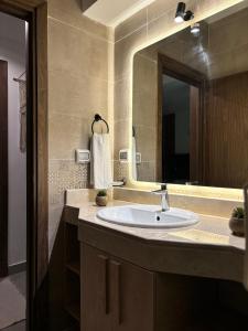 a bathroom with a sink and a large mirror at 2BR Modern & Comfy Apartment in luxury neighbourhood in Madinaty