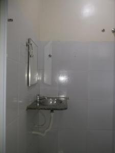 Baño blanco con lavabo y espejo en Brisa da Serra Pousada EM SOBRAL-CE, en Sobral