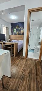 a room with a bed and a desk and a room with a window at Flat S4 Hotel - Águas Claras - Brasília in Brasilia