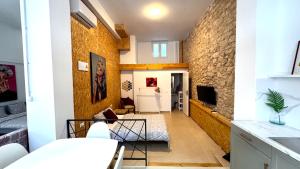 una sala de estar con una pared de piedra en Soho Boho Apartments - with sunny rooftop terrace and fiber optic internet, en Alicante