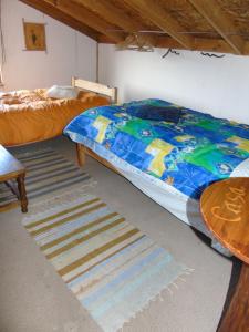 a bedroom with a bed and a table and a rug at Habitación Martin Pescador en Casa Quilanto in Coihaique