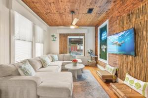 a living room with a couch and a tv at The Grand on Ave O in Galveston