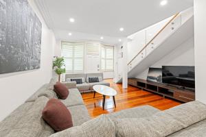 a living room with a couch and a tv at ICC & Darling Harbour Stylish 3BR House with Parking in Sydney
