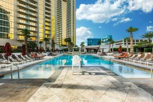 a swimming pool with lounge chairs and a hotel at MGM 1BR Mountain View Balcony 28802 in Las Vegas