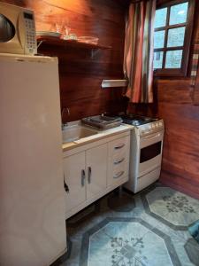 a kitchen with a stove and a sink and a refrigerator at Cabanas La Suisse in Campos do Jordão +117 photos