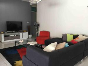 a living room with a couch and a tv at Villa de standing avec piscine à Saint-François in Saint-François