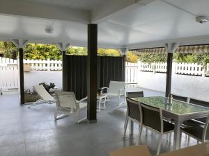 a patio with a table and chairs and a fence at Villa de standing avec piscine à Saint-François in Saint-François