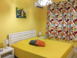 a bedroom with a bed with a yellow bedspread at Villa de standing avec piscine à Saint-François in Saint-François +15 photos