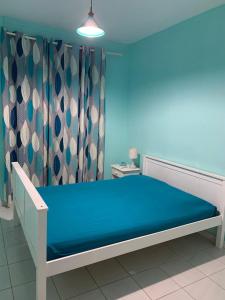 a bed in a room with a blue wall at Villa de standing avec piscine à Saint-François in Saint-François