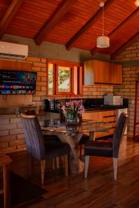 a kitchen with a table with chairs and a counter at Chalé 2 - Cordilheira Dos Canyons in Praia Grande +31 photos