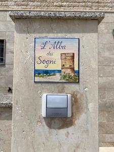 a sign on the side of a building with a sign at L'Alba dei Sogni in Marina Serra