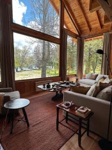 a living room with a couch and a large window at El Pedregoso Cabaña del Lago in Cholila