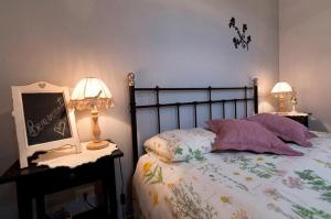 a bedroom with a bed with two lamps and a poster at La Maison Sabina in Passo Corese