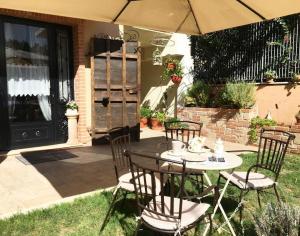 a table with chairs and an umbrella on a patio at La Maison Sabina in Passo Corese
