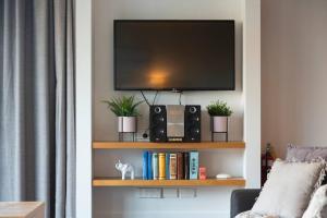 a living room with a tv on a book shelf at Mantra 2-- Lakeside Walking Track- Free Parking in Queenstown