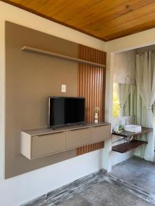 a living room with a flat screen tv on a wall at Chalé Frutas Especiais in Mucugê