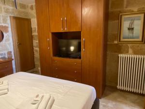 a bedroom with a bed and a cabinet with a tv at L'Alba dei Sogni in Marina Serra
