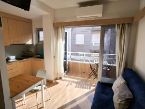 ein Wohnzimmer mit einem Tisch und eine Küche mit einem Balkon in der Unterkunft Relax and Beach in Las Palmas de Gran Canaria