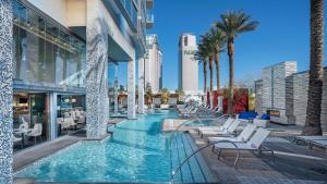 a pool with chairs and palm trees in a building at Mountain-View Studio w BALCONY ACCESS Palms 36305 in Las Vegas
