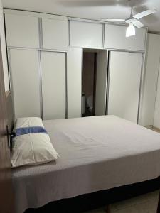 a bedroom with a bed with white walls and a ceiling at Casa na Praia da Pitoria in São Pedro da Aldeia +26 photos