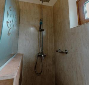 een douche met een douchekop in een badkamer bij Berberis Apart in El Chalten