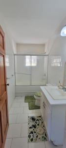 a white bathroom with a sink and a toilet at Dominic Apt at Mt Hartman in Golflands +16 photos