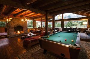 a living room with a pool table and a fireplace at Paralelo 41 in San Carlos de Bariloche