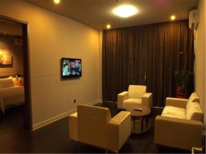 a room with two chairs and a couch and a tv at Jinjiang Inn Xiamen Jimei University Guomao in Xiamen +12 photos