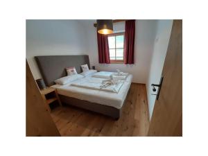 ホラースバッハ・イム・ピンツガウにあるAlpin Residenzen Top 12のベッドルーム1室(大型ベッド1台、窓、ベッドサイド付)