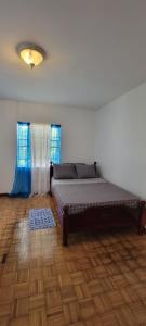 a bedroom with a bed and a wooden floor at Dominic Apt at Mt Hartman in Golflands
