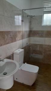 a bathroom with a toilet and a sink at Priyalanka Apartments in Panadura